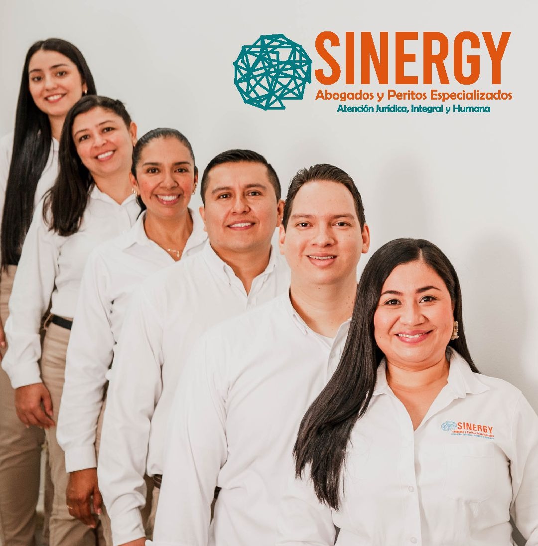 El equipo de Sinergy Abogados y Peritos Especializados, seis personas en camisa blanca frente al logo de la firma.